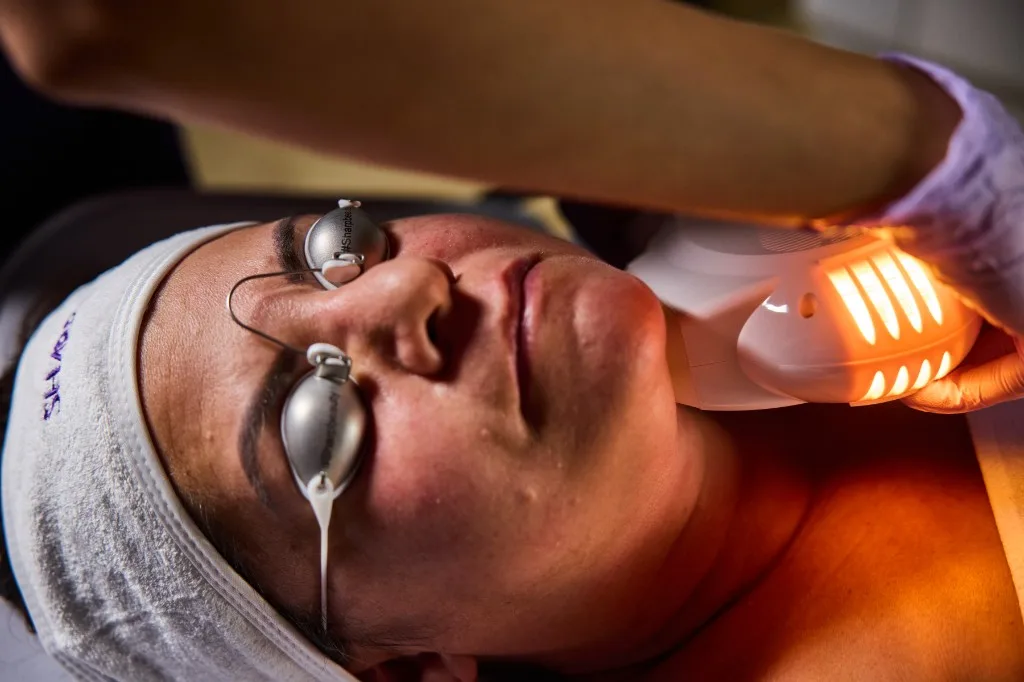 Close-up of infrared skin tightening applicator on the neck with warm energy delivery